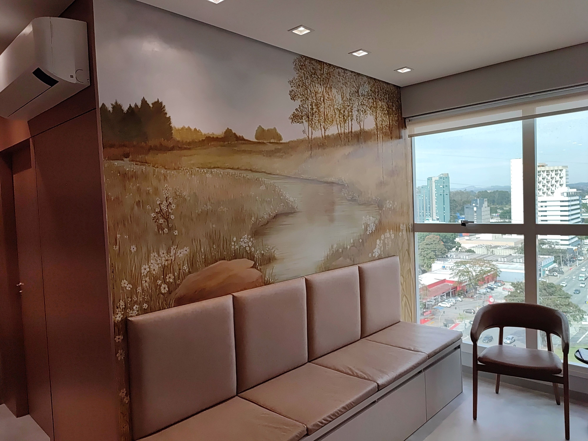 Recepção da Vivace, com assentos confortáveis, pintura na parede e vista de São José dos Campos